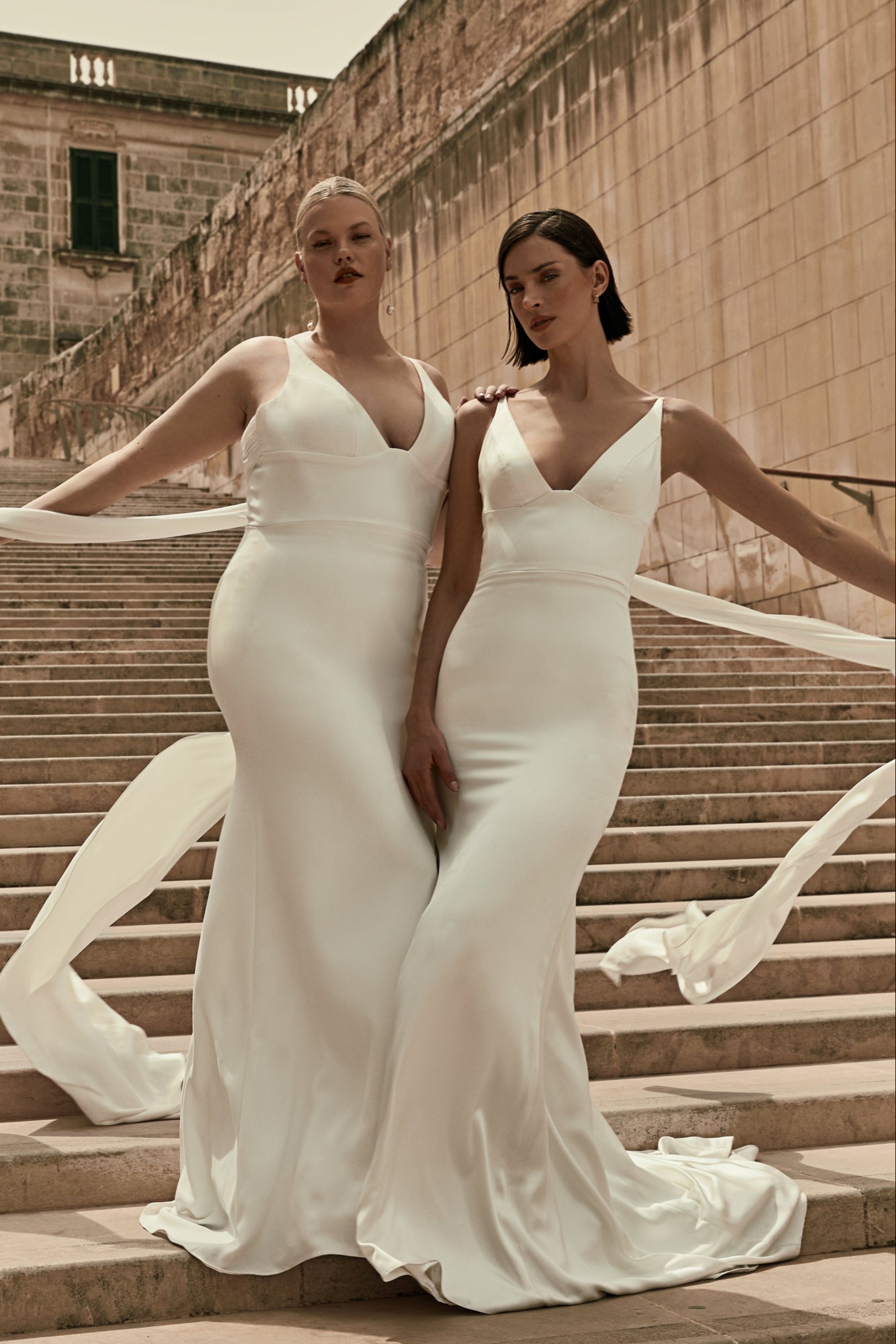Louise : An elegant wedding gown with a plunging neckline, wide waistband, and long back ties