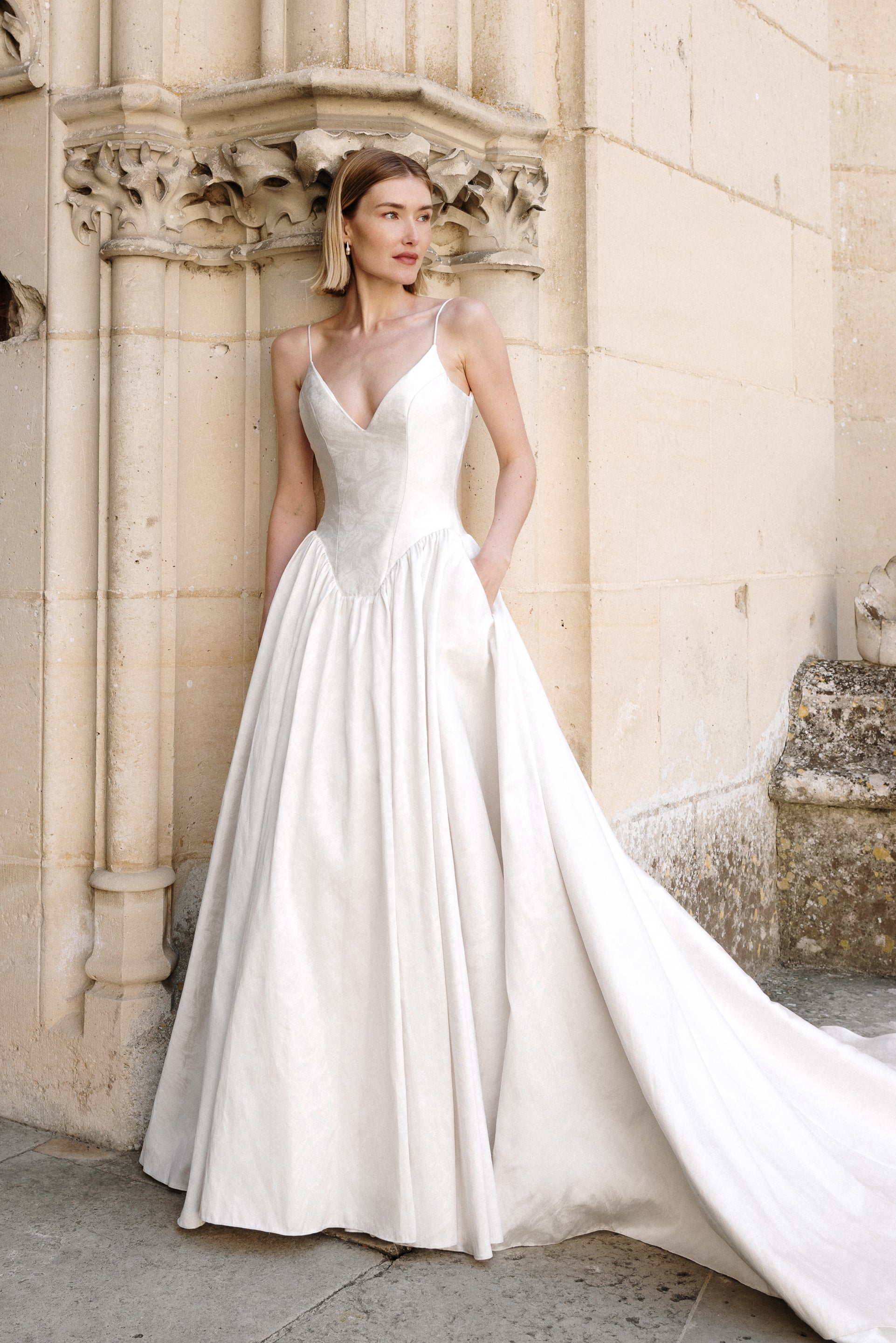Carmen : A stonewashed jacquard wedding gown with a dramatic squared basque waist and plunging neckline
