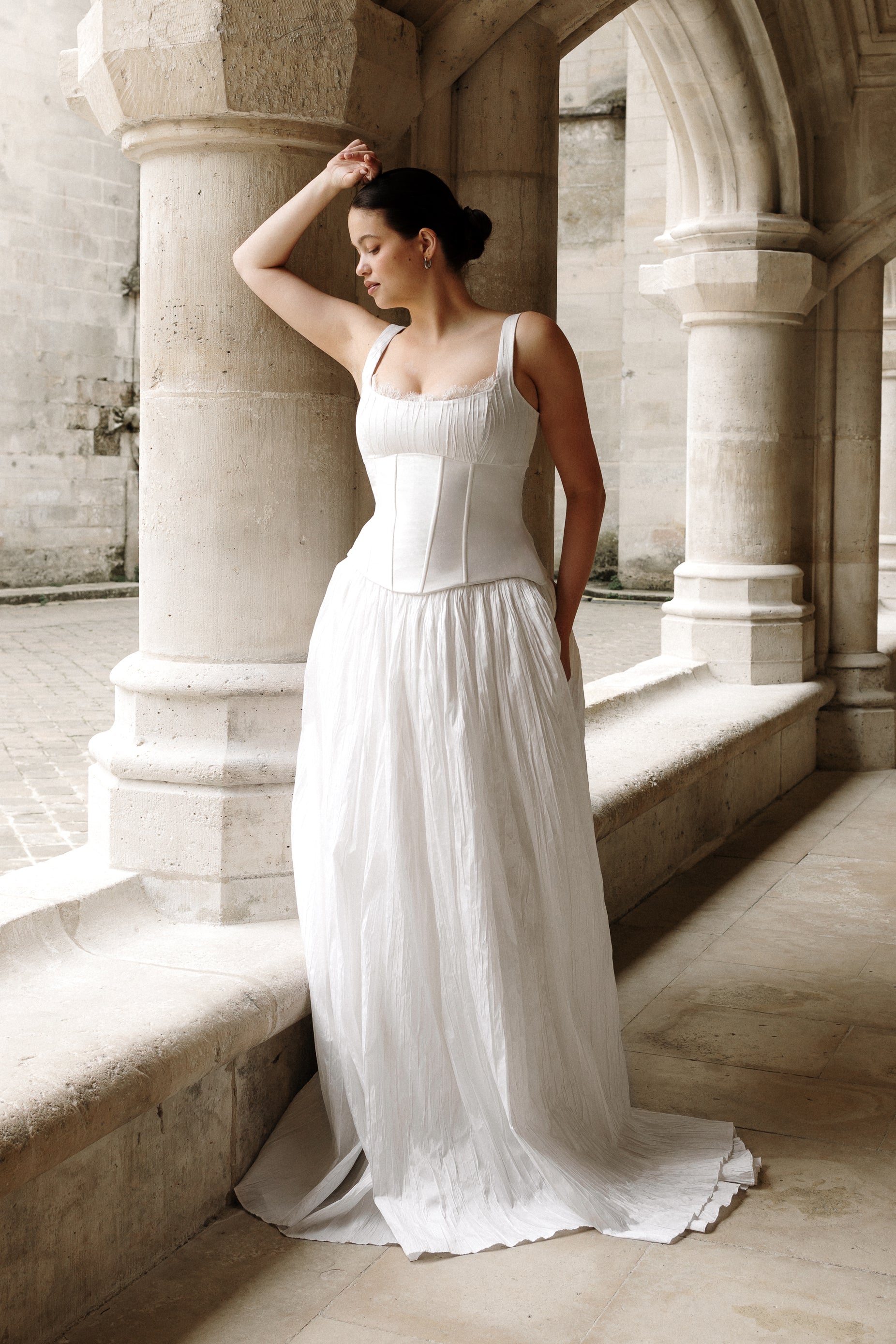 Valentina : A taffeta wedding gown with a scoop neckline, elongated corset-style bodice, and softly pleated skirt